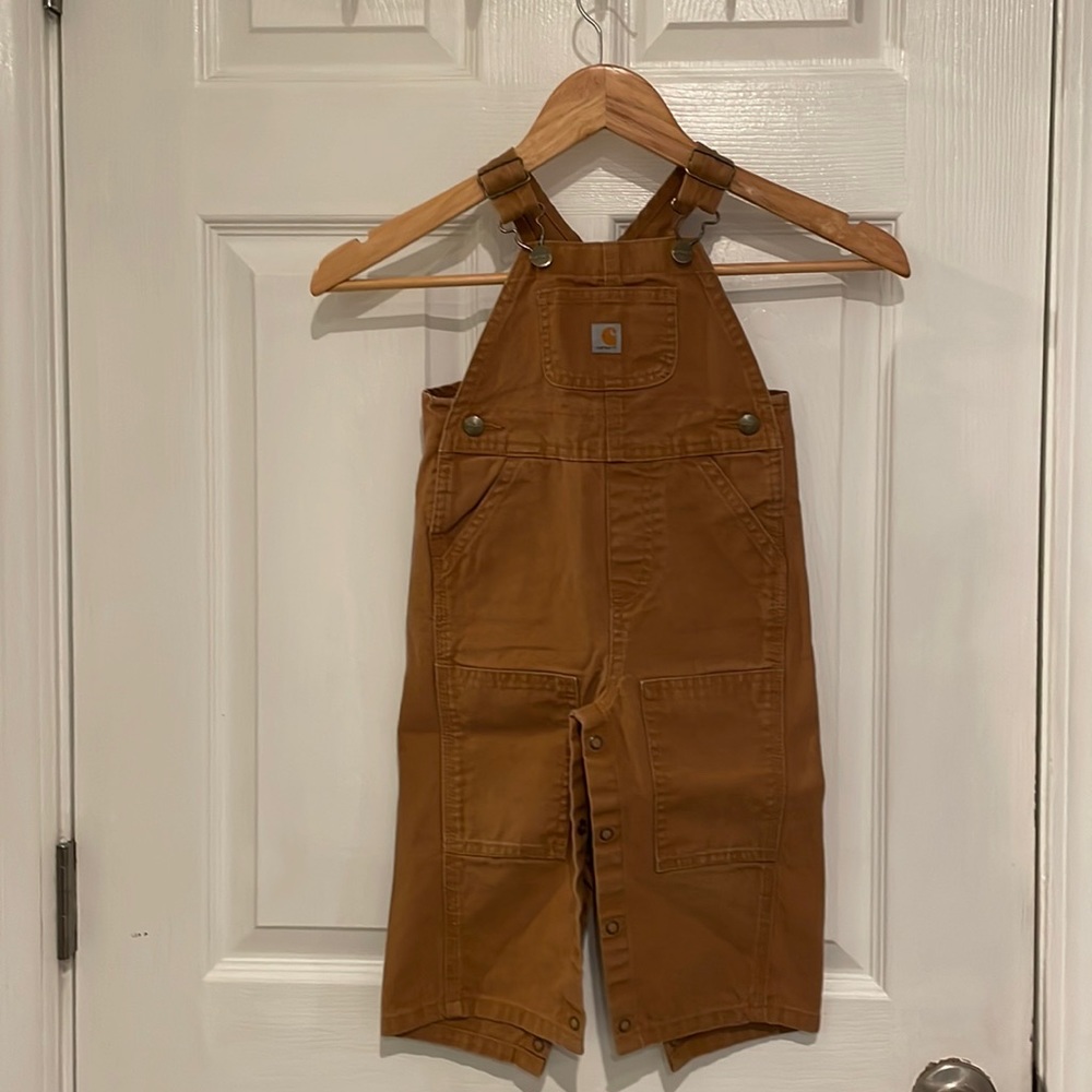 Carhartt overalls have buttons going down the legs and adjustable straps